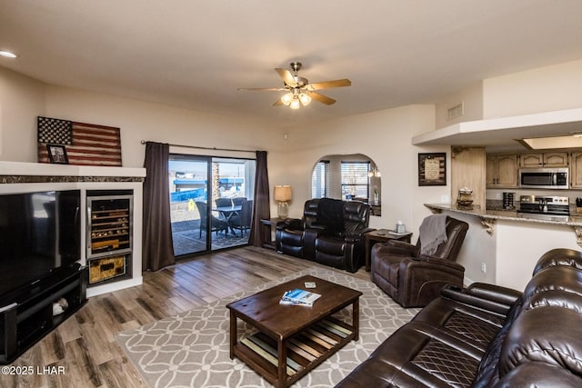 living room featuring ceiling fan, beverage cooler, and light wood-type flooring