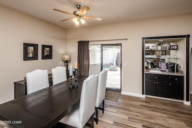 dining space with ceiling fan and light hardwood / wood-style flooring