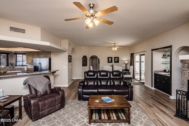 living room featuring ceiling fan and light hardwood / wood-style flooring