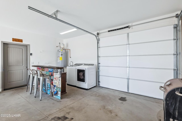 garage featuring water heater and washing machine and dryer