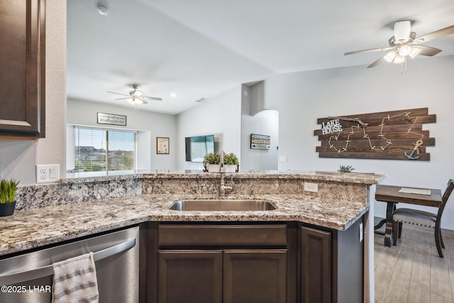 kitchen featuring dark brown cabinetry, dishwasher, light stone countertops, and a sink