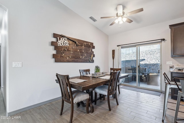 dining space featuring visible vents, baseboards, light wood-style floors, lofted ceiling, and ceiling fan