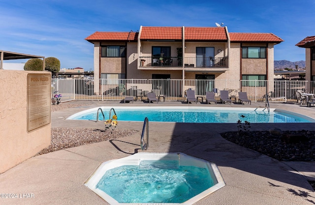 view of swimming pool with a hot tub