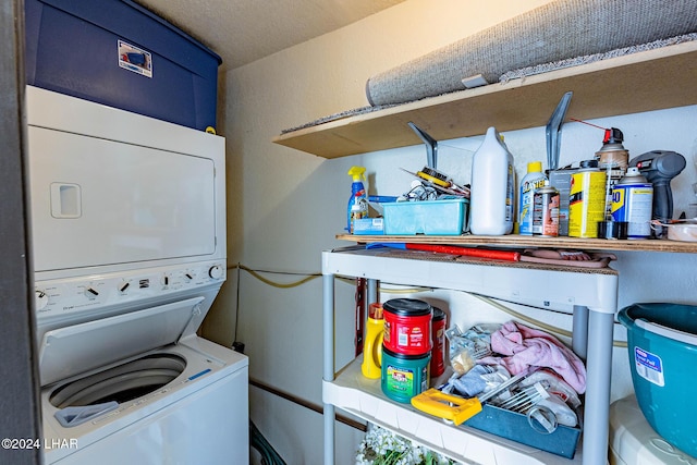 clothes washing area featuring stacked washer and clothes dryer