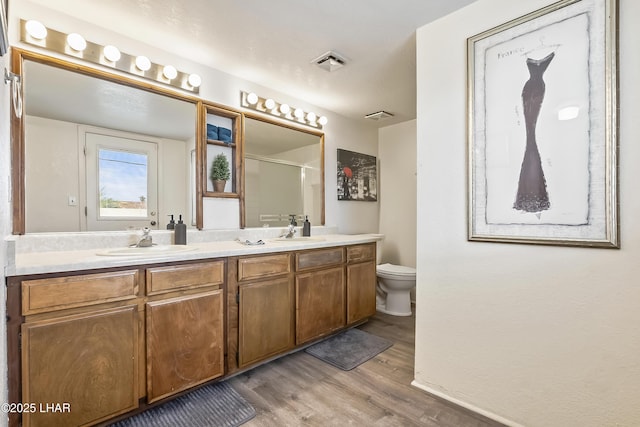 bathroom with vanity, hardwood / wood-style flooring, a shower, and toilet