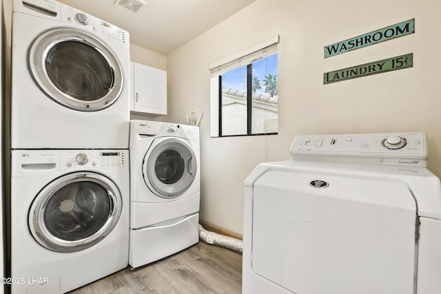 washroom with cabinets, independent washer and dryer, and light hardwood / wood-style flooring