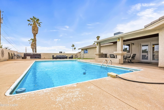 view of swimming pool with french doors, a hot tub, and a patio