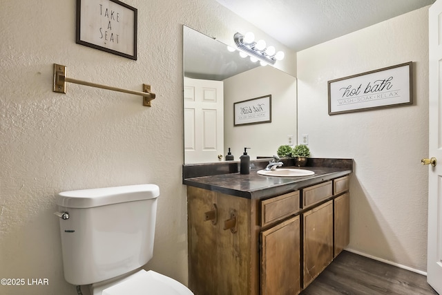 bathroom with vanity, hardwood / wood-style flooring, and toilet