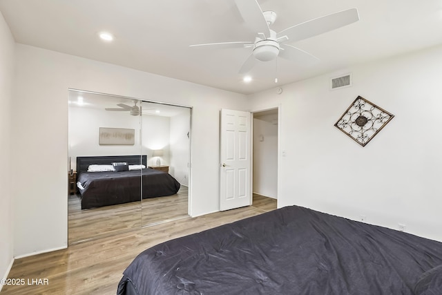 bedroom with hardwood / wood-style flooring, a closet, and ceiling fan