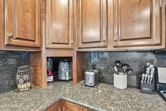 details featuring backsplash and dark stone counters