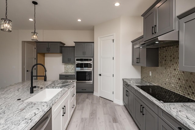 1650 E Sandra Dr, Lake Havasu City, AZ 86404 - kitchen with stainless steel appliances, a sink, under cabinet range hood, light stone countertops, and light wood-style flooring