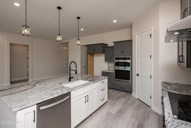 1650 E Sandra Dr, Lake Havasu City, AZ 86404 - kitchen with stainless steel appliances, a sink, wall chimney range hood, light wood finished floors, and light stone countertops