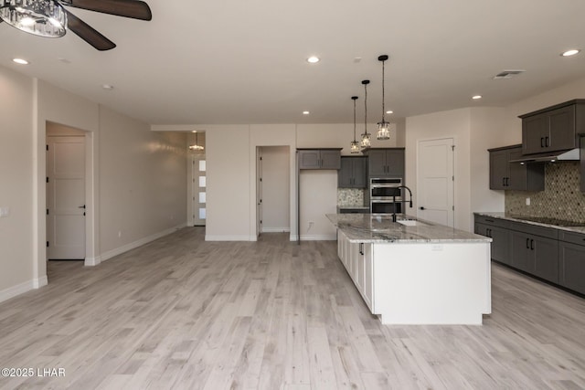 1650 E Sandra Dr, Lake Havasu City, AZ 86404 - kitchen featuring black electric cooktop, ceiling fan, decorative backsplash, light stone countertops, and recessed lighting