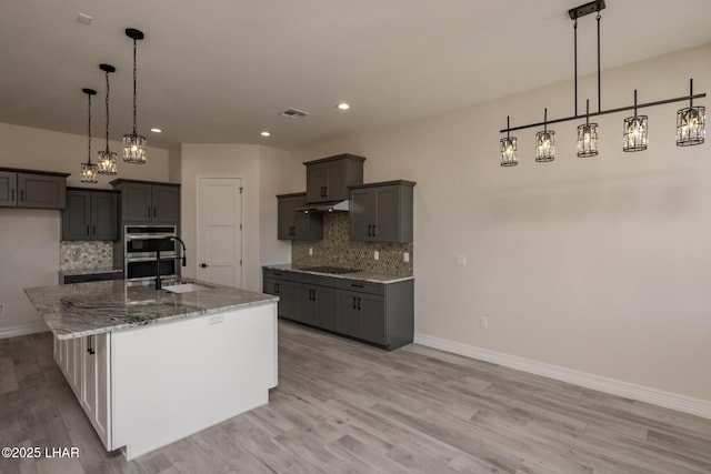 1650 E Sandra Dr, Lake Havasu City, AZ 86404 - kitchen with a sink, black electric cooktop, decorative backsplash, light stone counters, and recessed lighting
