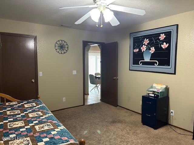 bedroom featuring ceiling fan and carpet