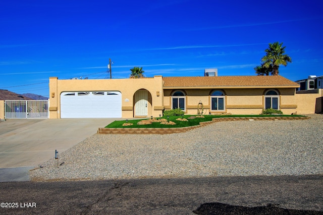 view of front of house with a garage, driveway, fence, and stucco siding