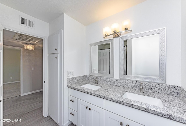 1880 Biscayne Ln, Lake Havasu City, AZ 86403 - bathroom with visible vents, a sink, double vanity, and wood finished floors