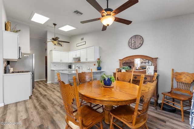 dining room featuring vaulted ceiling, light hardwood / wood-style floors, and ceiling fan