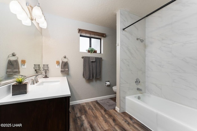 full bathroom featuring toilet, tiled shower / bath, a textured ceiling, vanity, and hardwood / wood-style floors