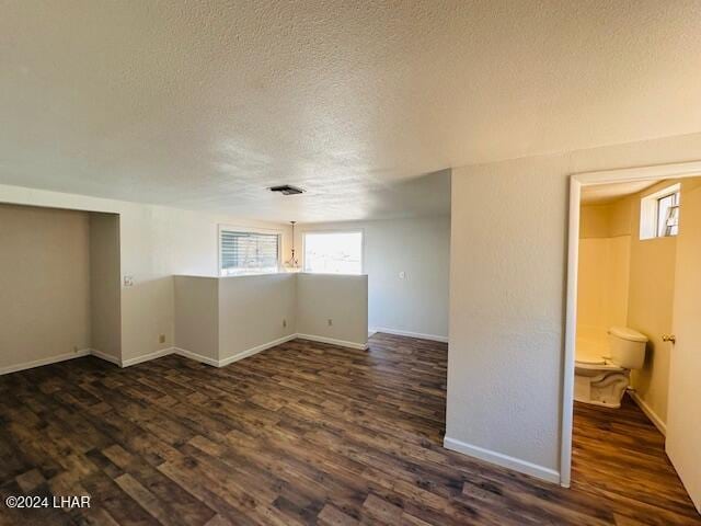 unfurnished room featuring dark hardwood / wood-style flooring and a textured ceiling