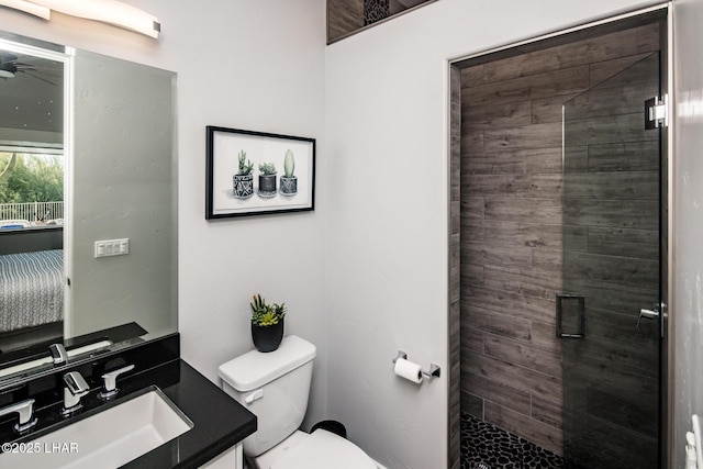 full bath featuring toilet, a tile shower, and vanity