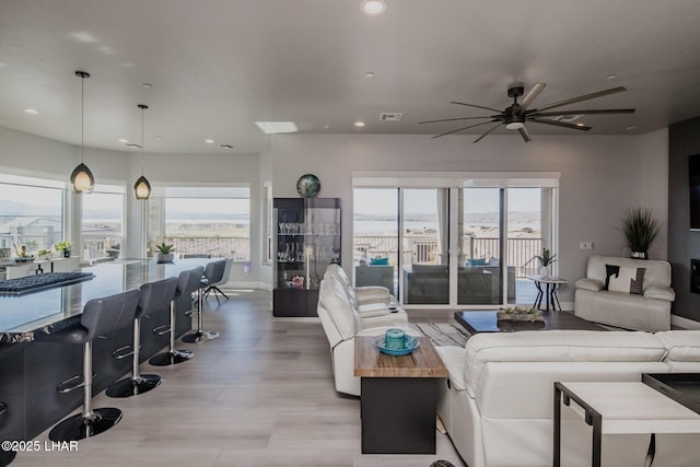 living area featuring a healthy amount of sunlight, visible vents, and recessed lighting