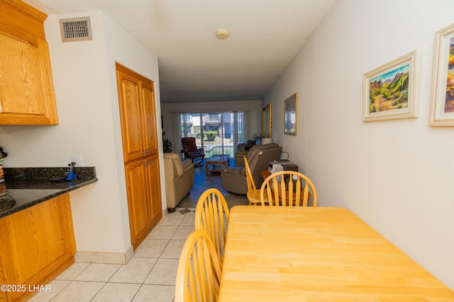 dining area with light tile patterned flooring and visible vents