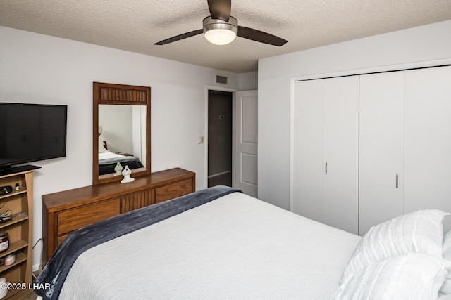 bedroom featuring ceiling fan, a textured ceiling, and a closet