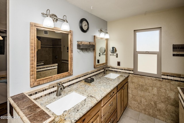 bathroom featuring tile patterned floors, vanity, and tile walls