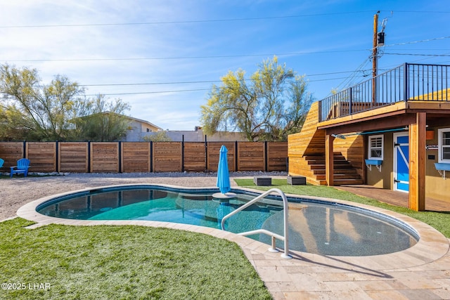 view of swimming pool with stairs, a wooden deck, a fenced in pool, a fenced backyard, and a lawn