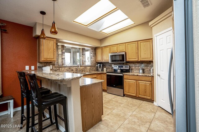 2780 Shasta Ln, Lake Havasu City, AZ 86403 - kitchen with a peninsula, appliances with stainless steel finishes, visible vents, and tasteful backsplash