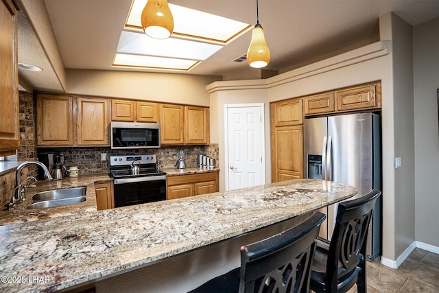 2780 Shasta Ln, Lake Havasu City, AZ 86403 - kitchen with appliances with stainless steel finishes, a sink, a kitchen breakfast bar, a peninsula, and backsplash