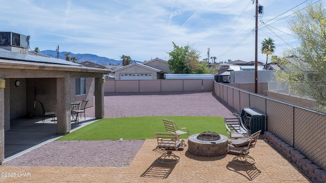 2780 Shasta Ln, Lake Havasu City, AZ 86403 - view of yard with an outdoor fire pit, a fenced backyard, a mountain view, cooling unit, and a patio area