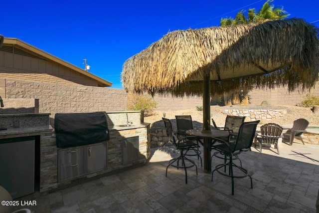 view of patio featuring outdoor dining area, a fenced backyard, a grill, and area for grilling