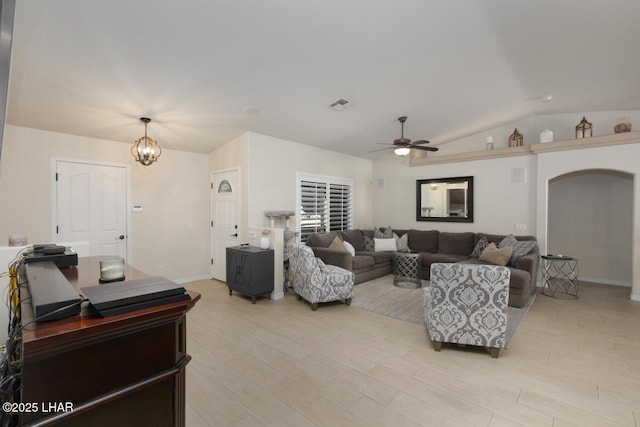 living room with arched walkways, visible vents, vaulted ceiling, light wood-type flooring, and ceiling fan with notable chandelier