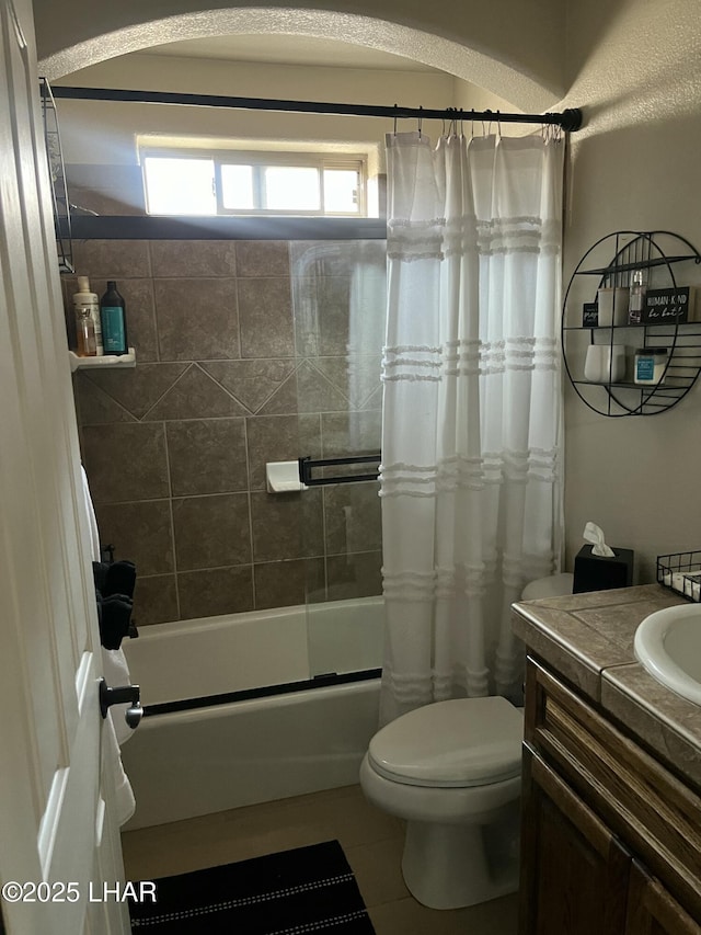 bathroom with tile patterned flooring, shower / tub combo with curtain, vanity, and toilet