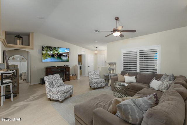 living area featuring light wood-type flooring, lofted ceiling, visible vents, and ceiling fan