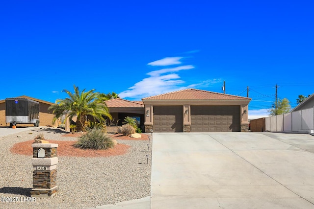 view of front of property with concrete driveway, stone siding, a tiled roof, an attached garage, and stucco siding