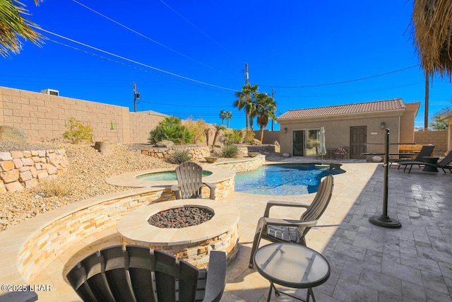 view of swimming pool featuring a fenced backyard, a fire pit, an in ground hot tub, a fenced in pool, and a patio area