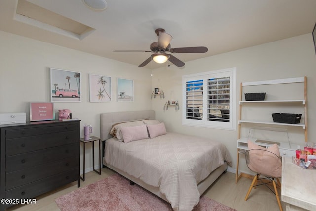 bedroom with attic access, baseboards, and a ceiling fan