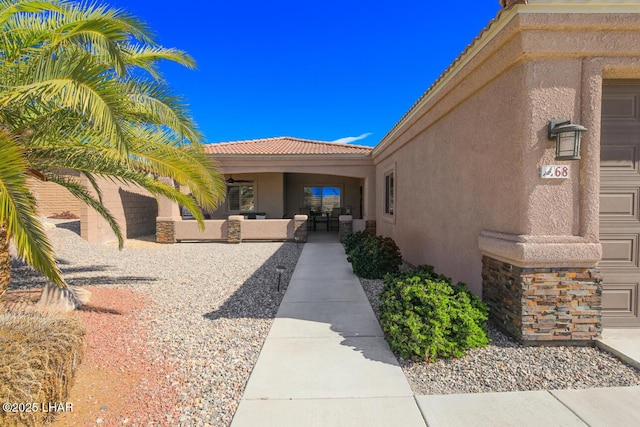 view of exterior entry featuring a tile roof and stucco siding