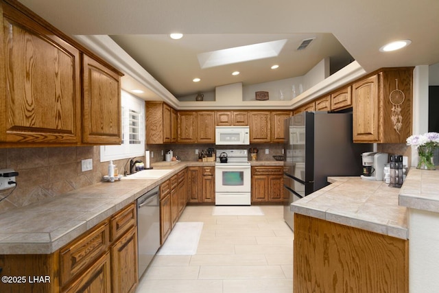 kitchen with stainless steel appliances, a sink, visible vents, and brown cabinets