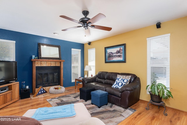 living room with wood-type flooring, a healthy amount of sunlight, and a fireplace