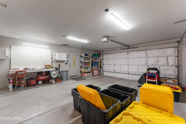 garage with a garage door opener and a workshop area