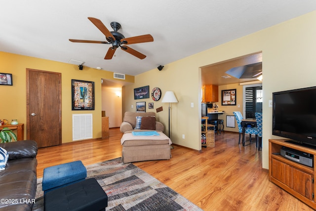 living room with light hardwood / wood-style floors and ceiling fan