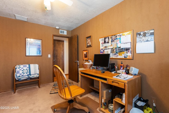 office space with ceiling fan, light colored carpet, and a textured ceiling