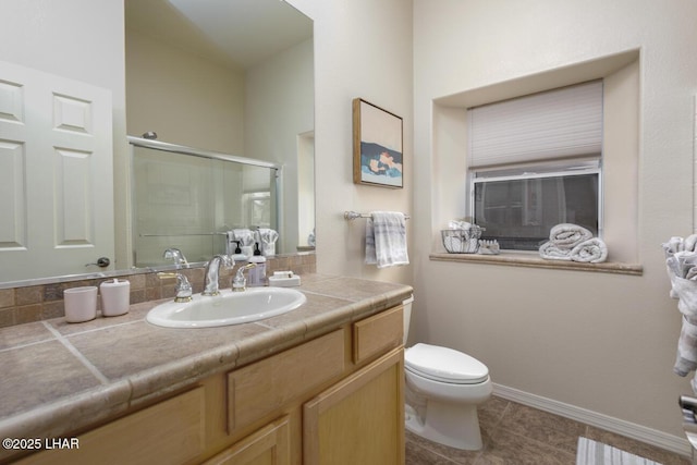 bathroom featuring baseboards, toilet, a shower stall, vanity, and tile patterned floors