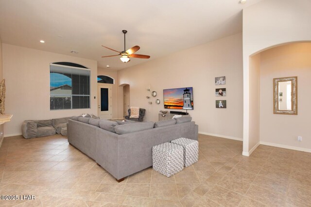 living room featuring arched walkways, light tile patterned flooring, a ceiling fan, and recessed lighting