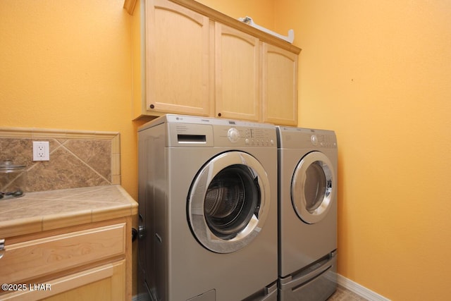 washroom featuring washing machine and dryer and cabinet space