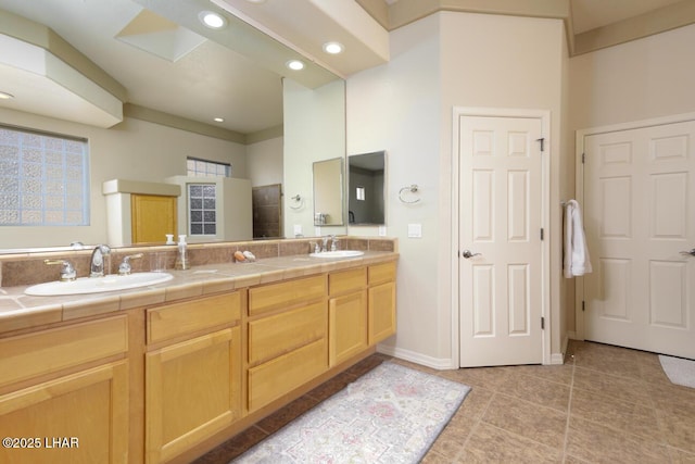 full bath featuring a sink, double vanity, tile patterned flooring, and recessed lighting
